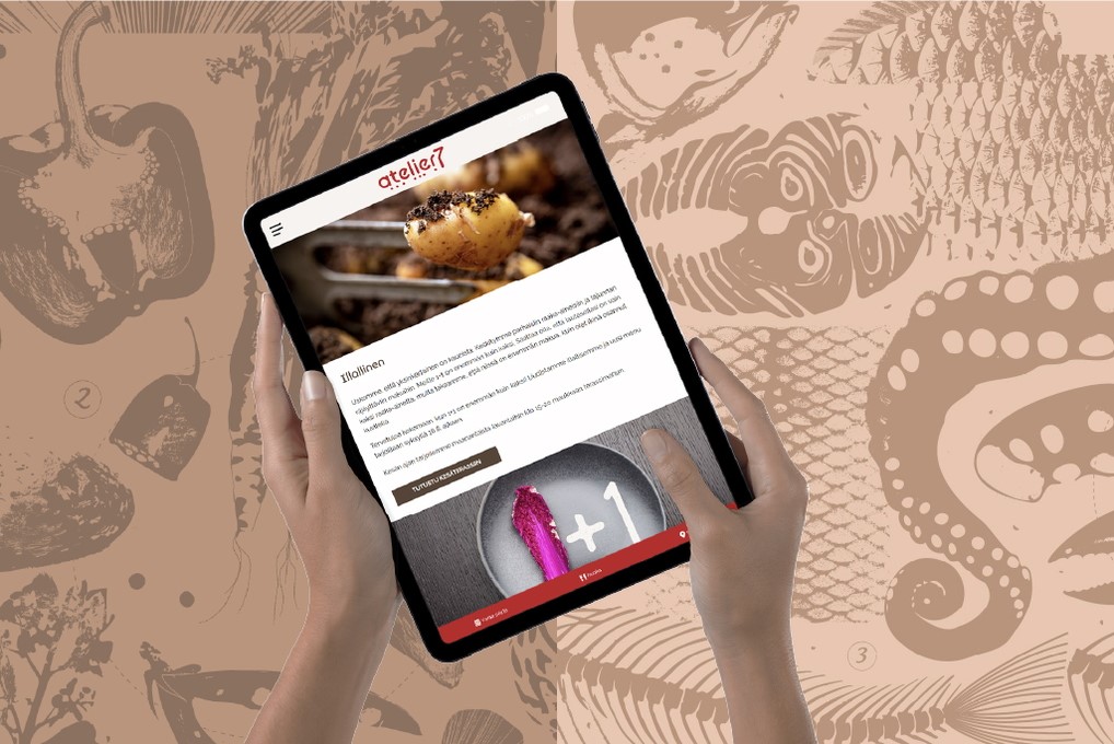 tabletilla atelier7 ravintolan verkkosivut, taustalla ravintolan graaista ilmettä
