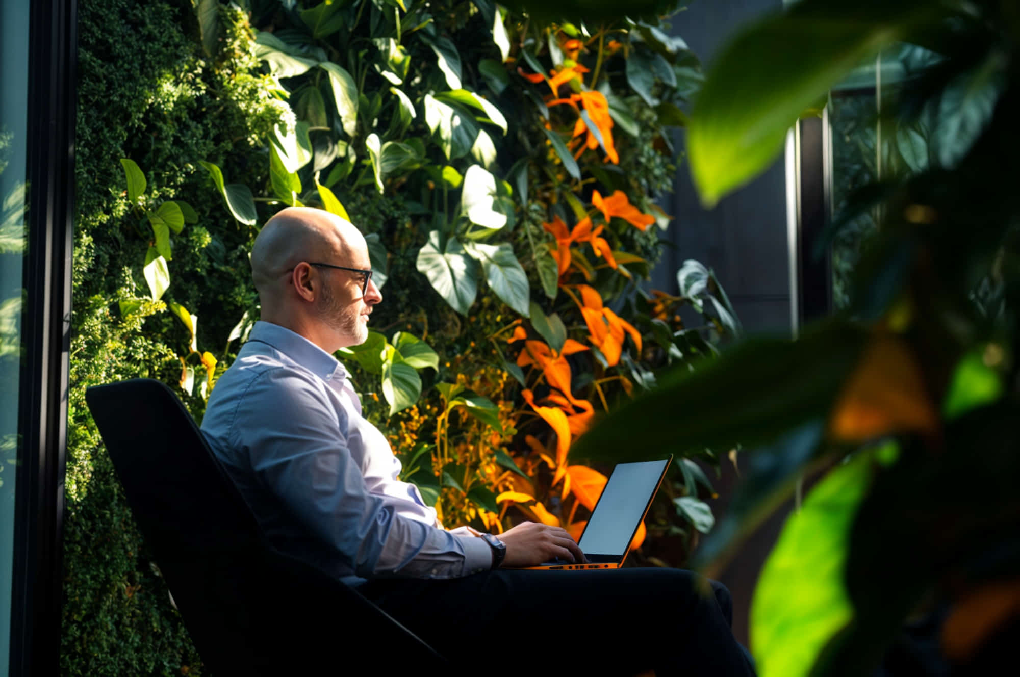 Mies työskentelee ulkona kannettavalla tietokoneella.